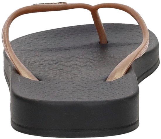 Achterkant van een zwarte Ipanema slipper met gouden bandje.