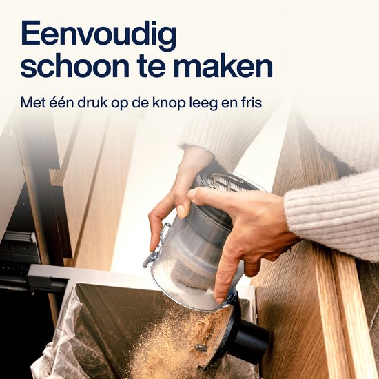 Vrouw leegt de stofbak van de Samako steelstofzuiger in een vuilniszak.