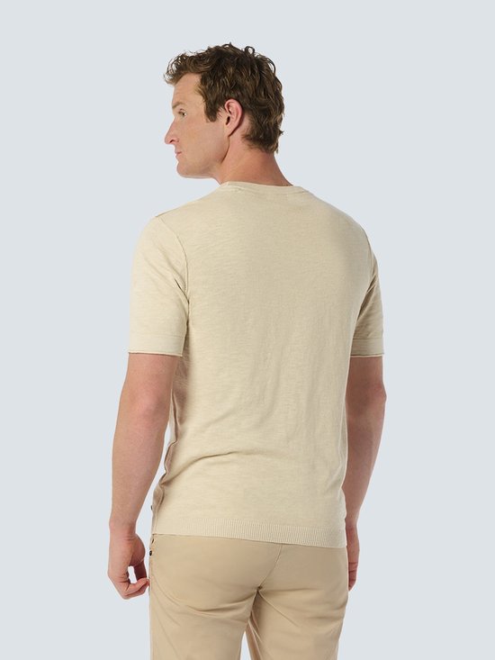 Dos d'un homme portant un haut beige à manches courtes.