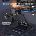 Zwarte racefietsstandaard met racestuur, pedalen en schakelpook op een vloerkleed, naast een bureau met monitor.