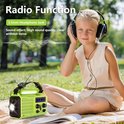 Meisje met koptelefoon luistert naar muziek van een groene noodradio met LED lamp.