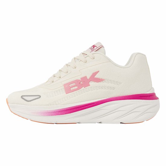 Crème-kleurige lage sneaker met roze BK-logo, roze accenten en oranje zoolrand.