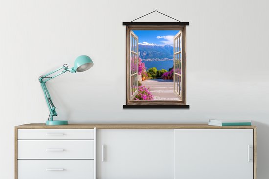 Une affiche textile avec porte-affiche est suspendue au-dessus d'une commode blanche avec une lampe bleue à côté.