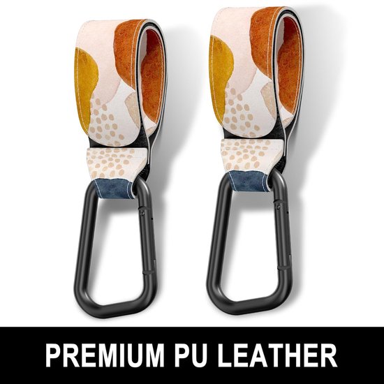 Twee kinderwagenhaakjes met abstracte vlekken in okergeel, oranje, roze en beige met zwarte karabijn sluitingen. Bovenste tekst: 'PREMIUM PU LEATHER'.