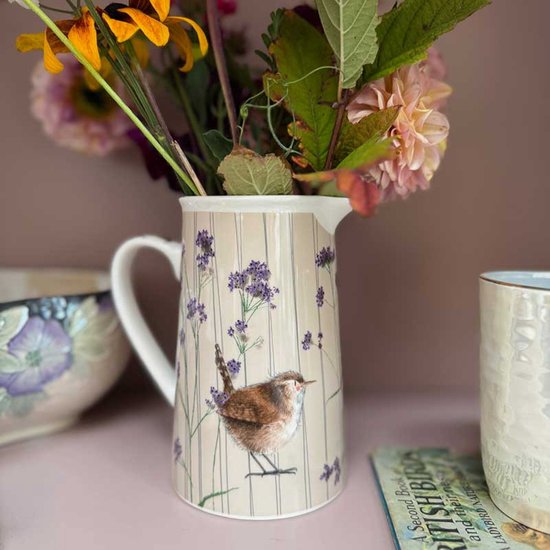 Kruik met een winterkoninkje en verbena bloemen op een beige achtergrond met verticale strepen.