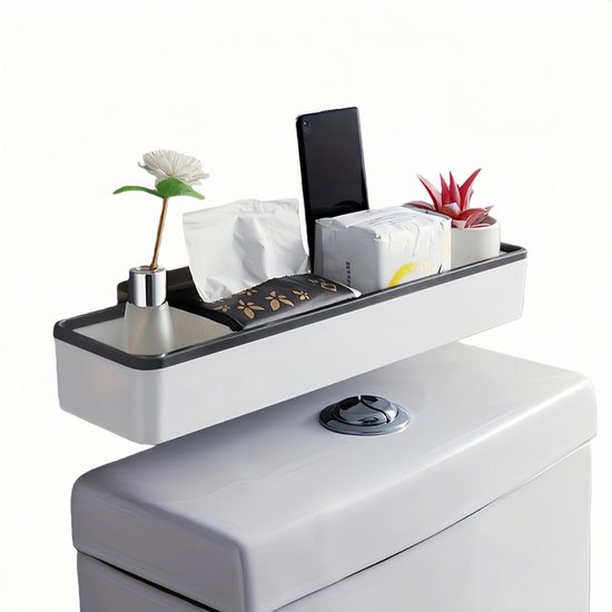 Witte badkamerplank met donkergrijze rand, met telefoon, zakjes tissues, plantje en decoratieve bloem.