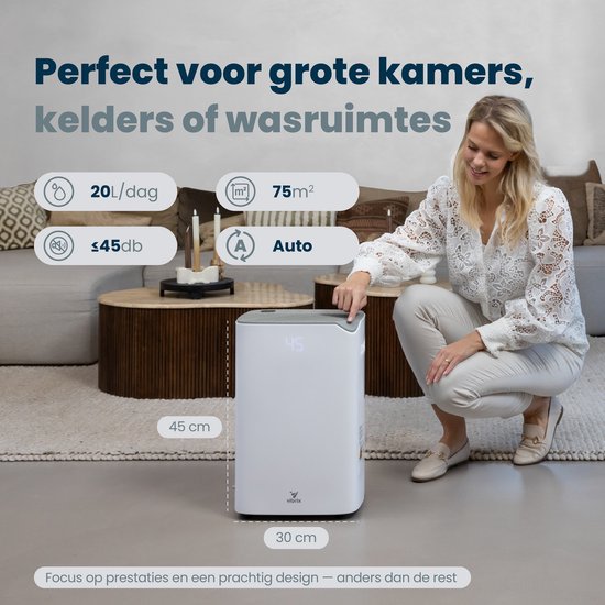 Vrouw in een woonkamer knielt naast een witte Vibrix luchtontvochtiger met display '45'. Afmetingen 30x45cm. Geschikt voor grote kamers.