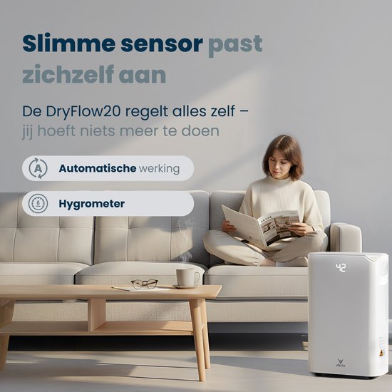 Witte Vibrix luchtontvochtiger met display '42' naast een vrouw die op een bank leest. Beschrijft slimme sensoren en automatische werking.