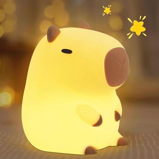 Een zacht gloeiend, geel capybara nachtlampje op een tafel.