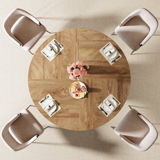 Van bovenaf gezien: ronde houten eettafel met visgraatpatroon en bloemstuk.