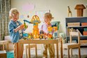Twee lachende kinderen spelen met geel bouwspeelgoed met kranen en voertuigen.