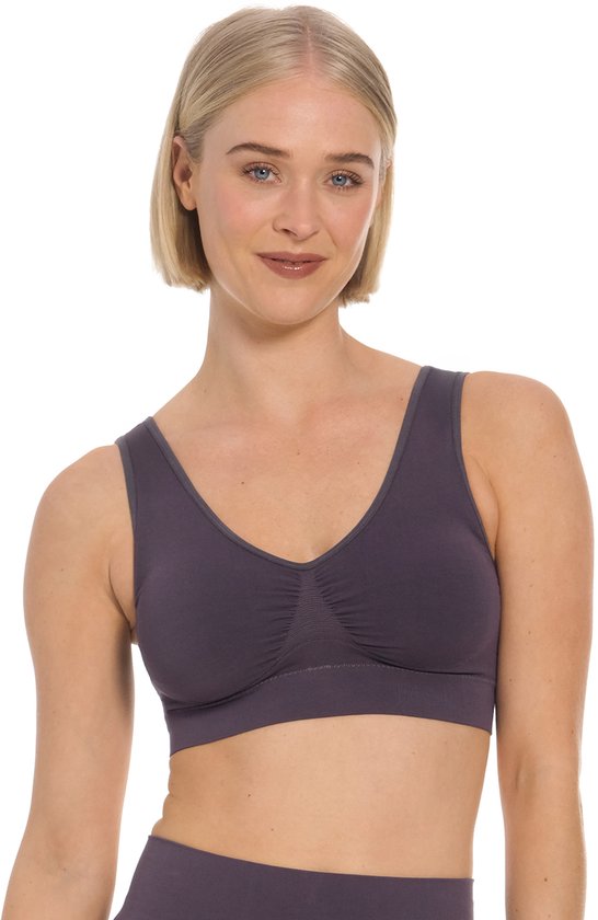 Blondine met blauwe ogen, draagt een paarsgrijze beha met V-hals en gerimpelde cups.