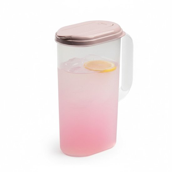Pichet d'eau transparent avec un couvercle vieux rose, rempli de limonade rose, de glace et d'une rondelle de citron.