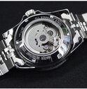 Achterkant van een zilverkleurig horloge dat het automatische uurwerk toont.