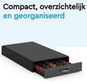 Boîte noire pour capsules, tiroir ouvert rempli de capsules Nespresso rouges et marron.