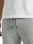 Detail van de koordjes van een lichtgrijze joggingbroek.