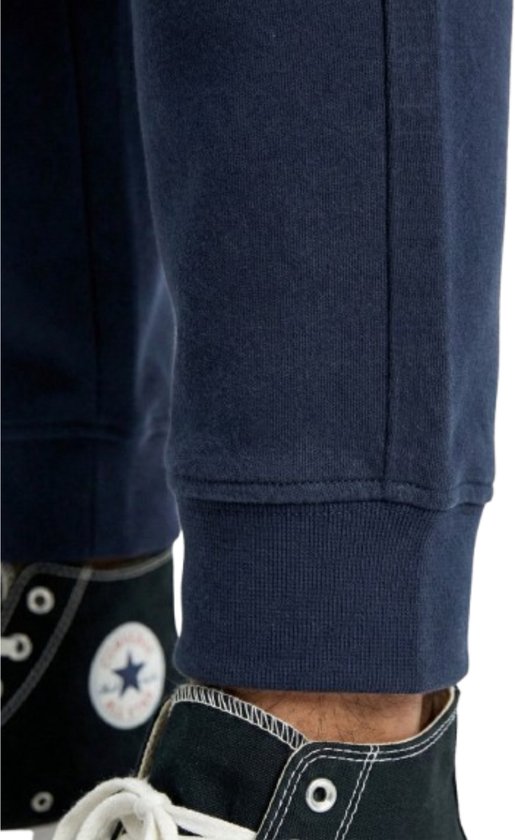 Detail van de onderkant van een navy joggingbroek met elastische boord.