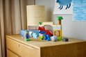 Rode en blauwe T-Rex met groene goblin, op een houten kast.