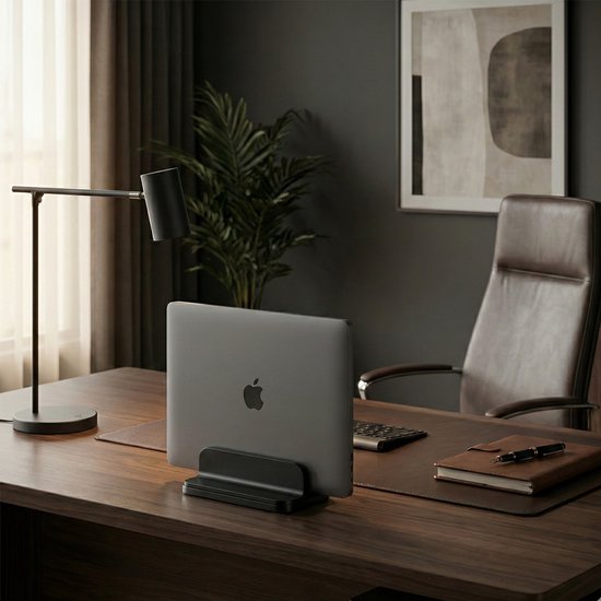 MacBook in zwarte standaard op een bureau.