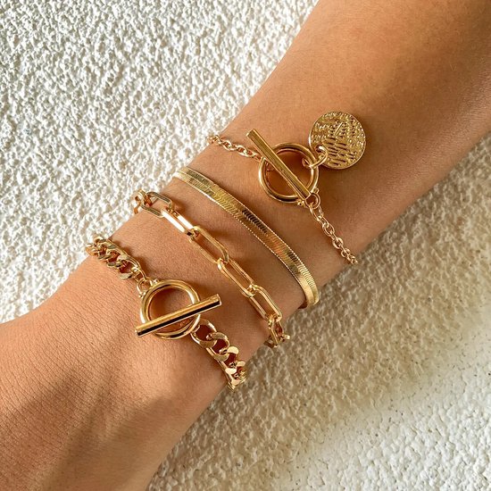 Vier gouden schakelarmbanden met muntsluiting, platte schakel en toggle-sluitingen.
