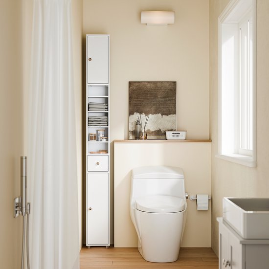 Witte smalle badkamerkast naast een toilet, met handdoeken en potjes op de planken.