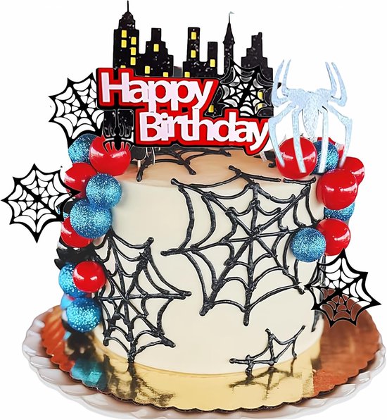 Verjaardagstaart met spinnenwebdecoratie, rode, blauwe en zwarte ballen, stadssilhouet en "Happy Birthday"-tekst.