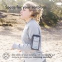Vrouw draagt een grijze sportarmband met telefoon om haar arm terwijl ze rent. Ze heeft oordopjes in. Tekst 'Space for your earplugs' staat bovenaan.