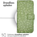 Groen telefoonhoesje met bladerpatroon op een draadloze oplader.
