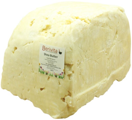 Een groot blok ongeraffineerde shea butter met een etiket van Berivita 'Shea Butter Huid & Haar'.