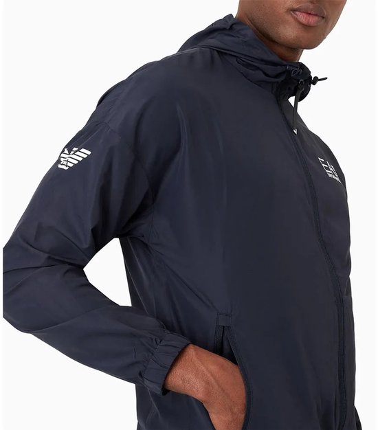 Detail van de linker mouw van een marineblauw EA7 trainingsjack met gestreepte EA7 logo's.