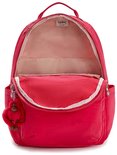 Sac à dos Kipling rouge ouvert avec doublure rose, des tons beiges et un porte-clés singe rouge.