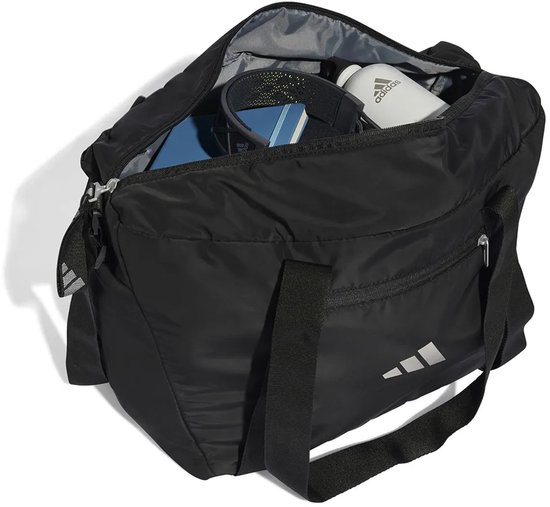 Zwarte sporttas met open rits, gevuld met sportartikelen. Adidas logo op de voor- en zijkant.