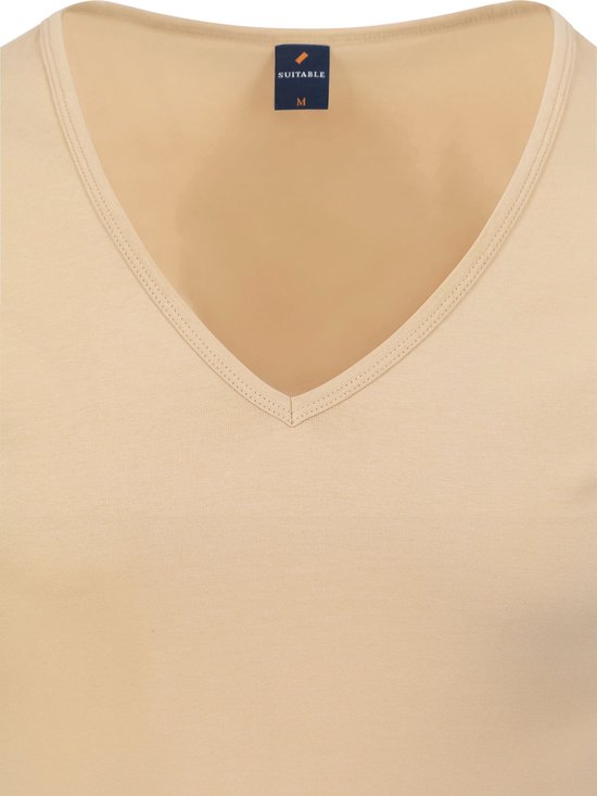 Detail van de V-hals van een beige t-shirt met label.