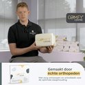 Man met kussen, met opdruk Comfy Centre. Op de achtergrond stapels kussens.