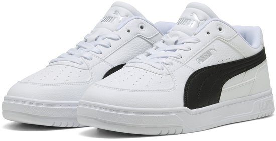 Paar witte Puma sneakers met zwarte strepen op de zijkant en witte zolen.