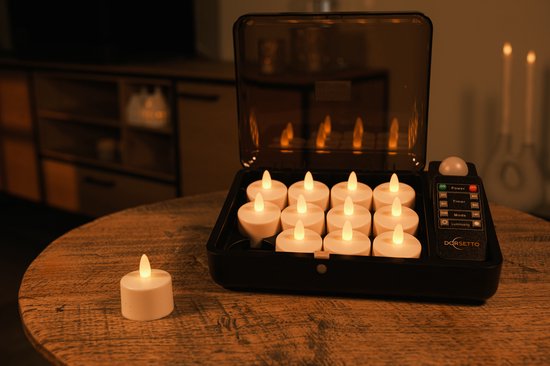 Oplaadbare LED waxinelichtjes in een zwarte oplader met afstandsbediening. Eén los lichtje staat ernaast.