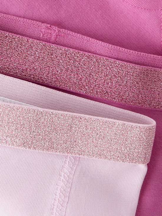 Detail van glitter taillebanden in roze en lichtroze op hipsters.