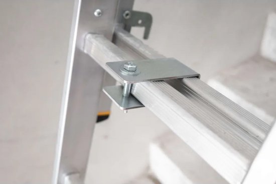 Close-up van een metalen adapter op een aluminium ladder met een bout en moer.