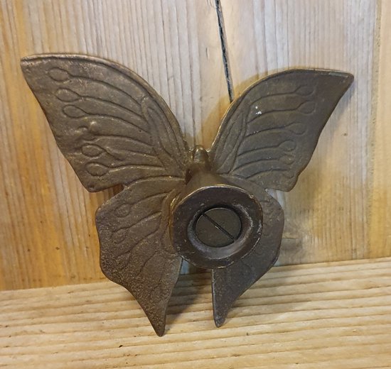 Papillon en bronze aux ailes détaillées, avec un objet rond central à vis.