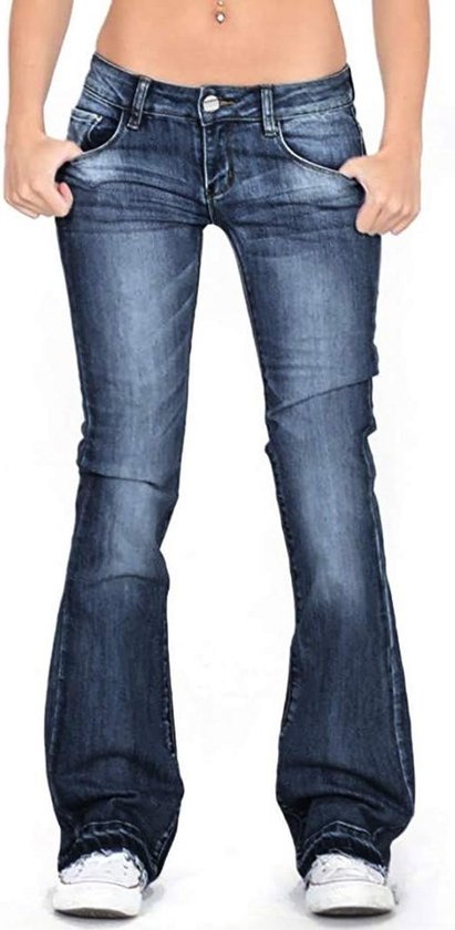 Donkerblauwe, uitlopende jeans met een lage taille en stonewashed effect. Zichtbaar vanaf de heupen tot de enkels, met witte sneakers.