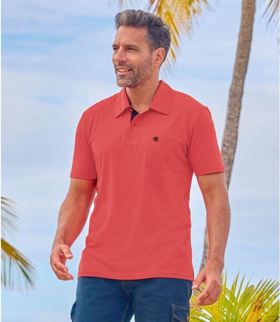 Man met rode polo met korte mouwen en borstzak met zwarte plantenprint.