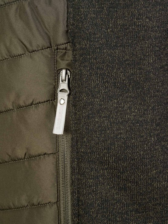 Sluiting met rits en schuifje met logo op een olijfgroene gewatteerde bodywarmer met donkergrijs gebreide zijkanten.