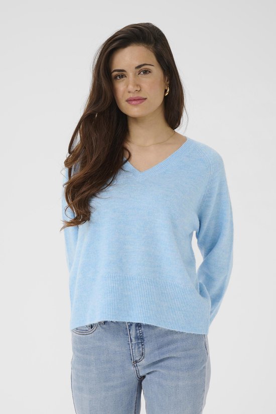 Model in een lichtblauwe melange trui met V-hals en jeans.