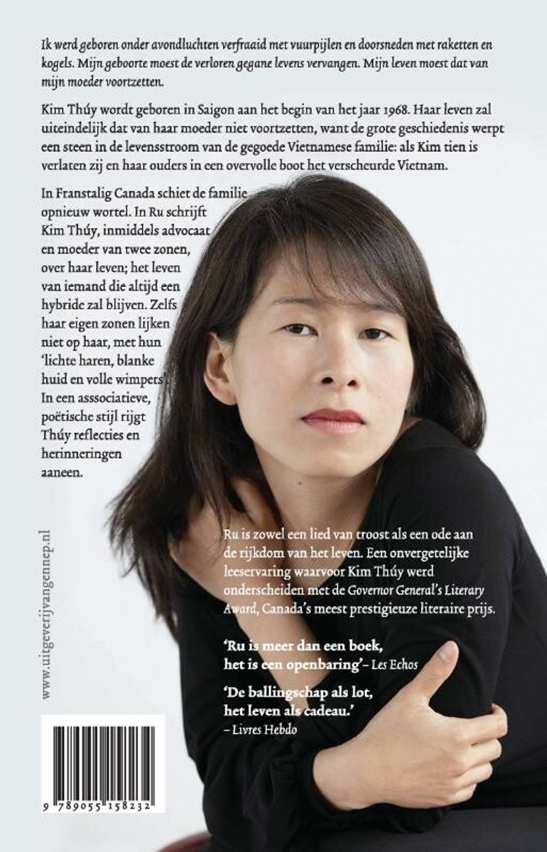 Kim Thúy, een vrouw van Aziatische afkomst, met lang donker haar en een lichte huid, kijkt met een intense blik naar de camera. Ze draagt een zwarte top.