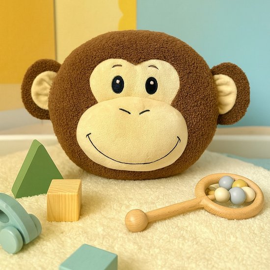 Bruin rond sierkussen met aapgezicht, in een kinderkamer met speelgoed.