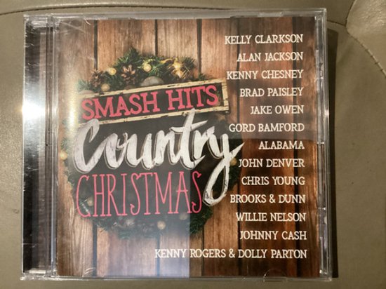 Cd-hoes met de titel 'Smash Hits Country Christmas' op een houten achtergrond. Met een kerstkrans en een lijst met artiesten.