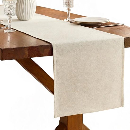 Beige linnenlook tafelloper met textuur op een houten tafel.