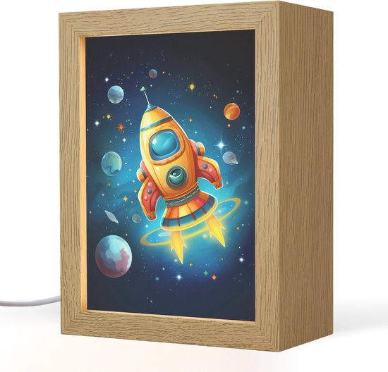 Une veilleuse en bois avec une fusée orange, des planètes et des étoiles sur fond sombre. La lampe est éclairée.