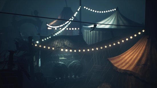 Een figuur loopt over een koord, verlicht door guirlandes, in een circusachtige setting met tenten.