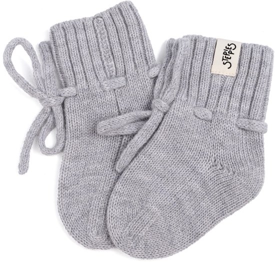 Lichtgrijze gebreide babyslofjes met gestreepte boord, striklint en 'Steppies' label, op witte achtergrond.